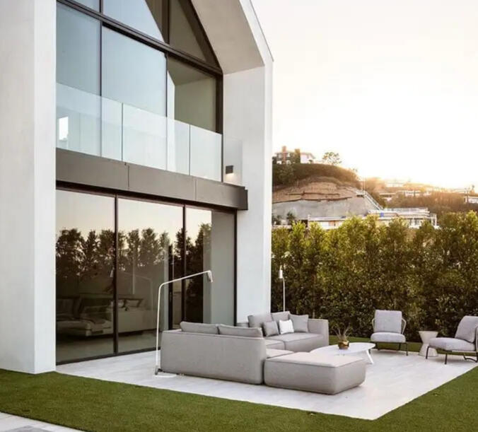 Contemporary double-volume home with full-height glazing opening onto a terrace